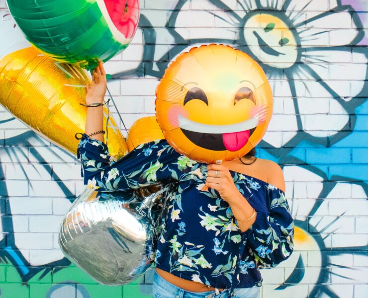 Person with happy balloon over their face