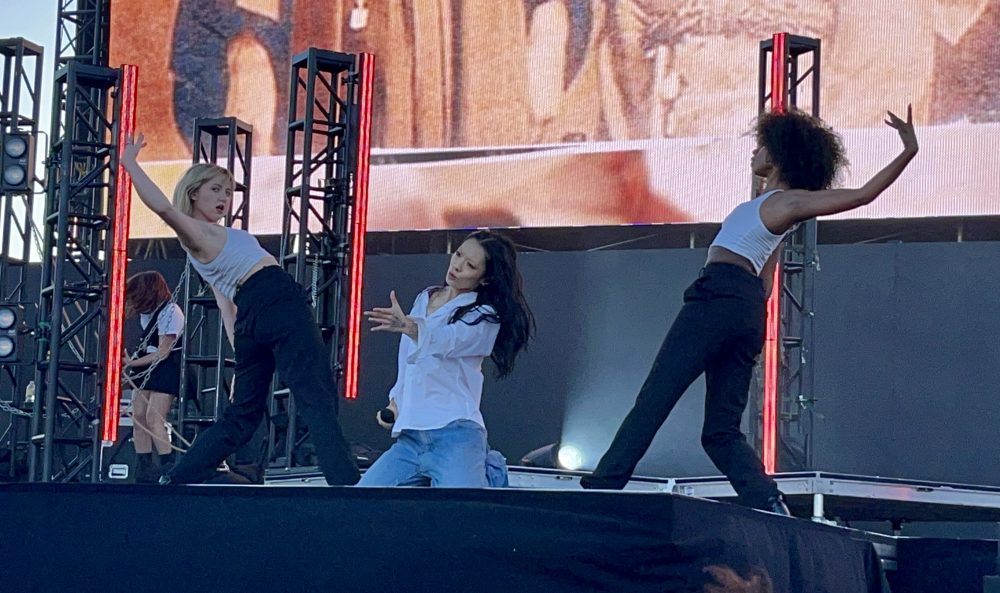 Portola Festival artist Rina Sawayama on her knees & dancers on either side mid dance move