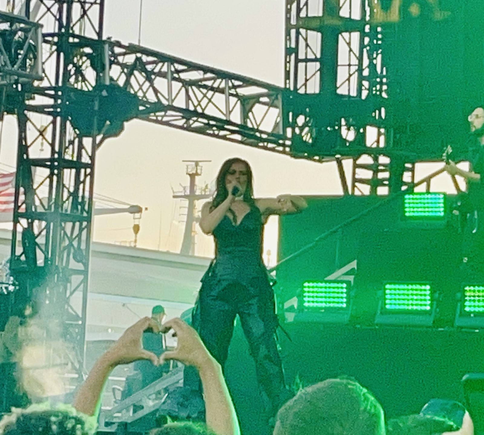 Portola Festival artist Nelly furtado onstage with an audience member making heart hands in front of her