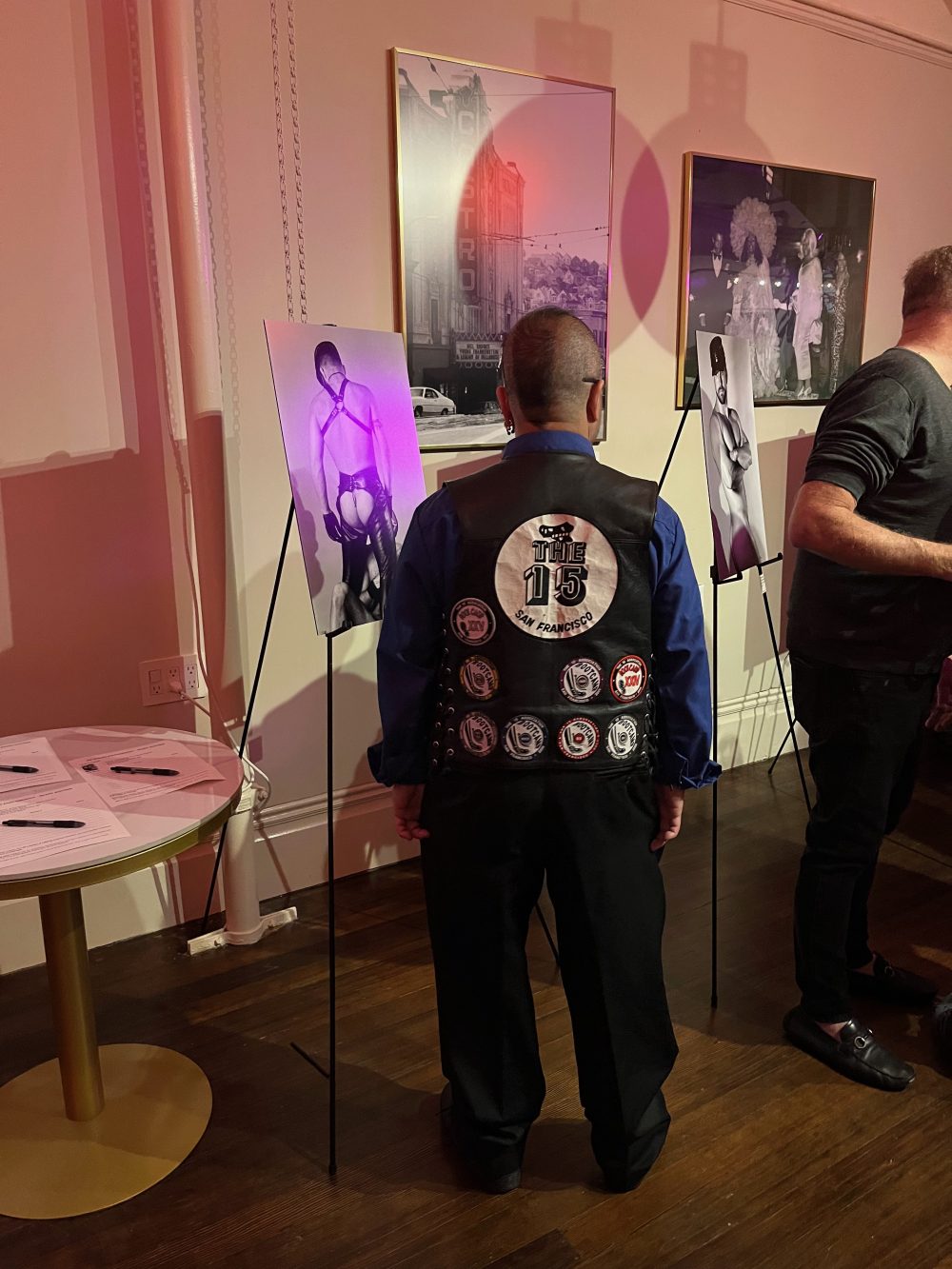 a photo of a amab queer showcasing his patches on his leather vest