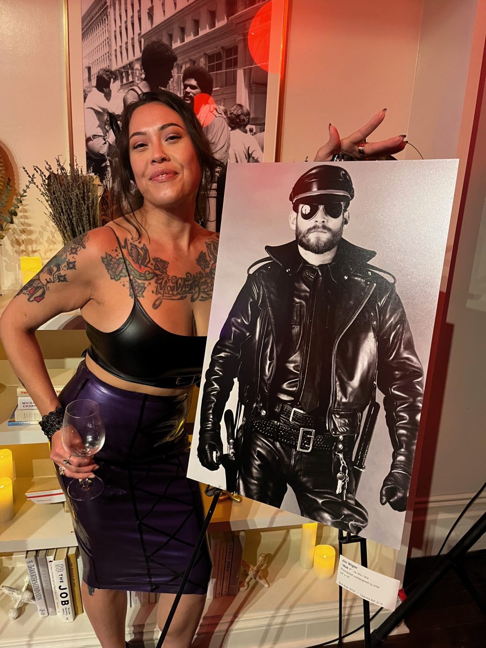 the author of the story poses in latex next to a Wigler photograph