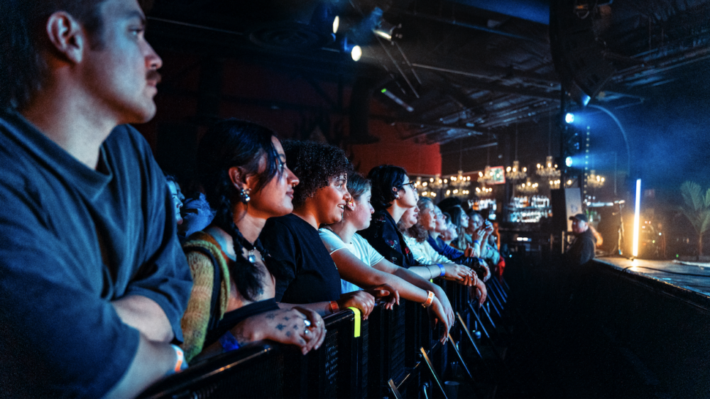 close up of the front row audience members leaning on the barricade