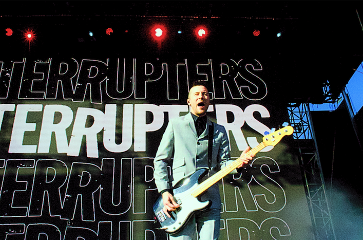 Justin Bivona plays bass with a silly expression