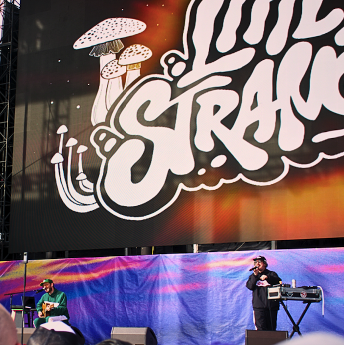 LIttle Stranger onstage beneath their logo
