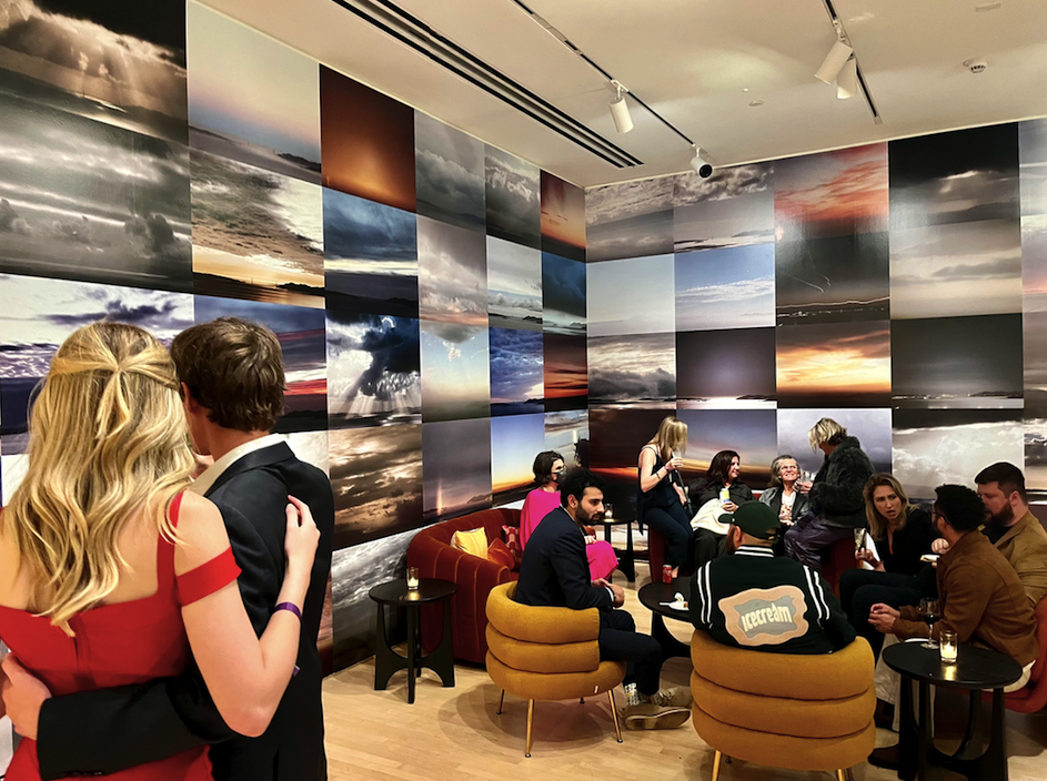 Guests mingling in another lounge surrounded by images of the ocean and sky