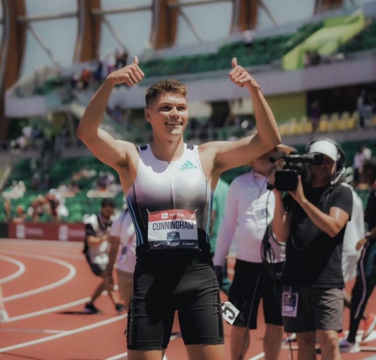 Track and field athlete Trey Cunningham, a white man with light brown hair, giving a thumbs up in his uniform.