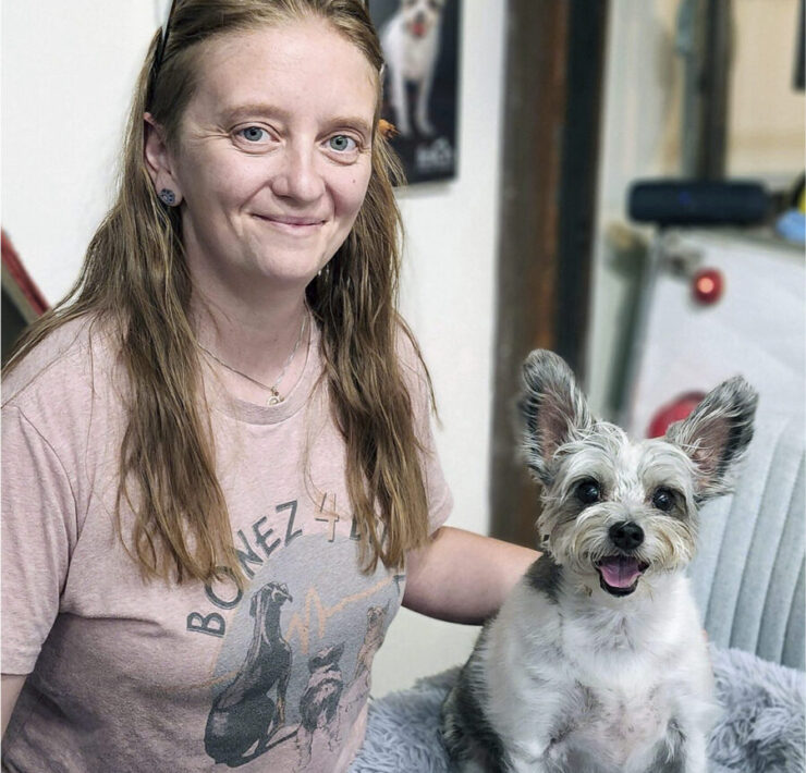 Karina Tittjung of Bonez 4 Budz poses with a small dog with large ears.
