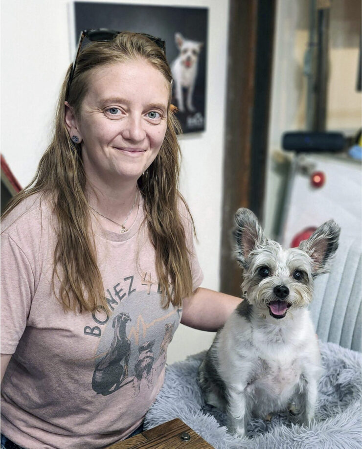 Karina Tittjung of Bonez 4 Budz poses with a small dog with large ears.