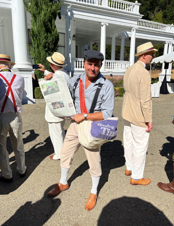 old fashioned paperboy holds up vintage news paper