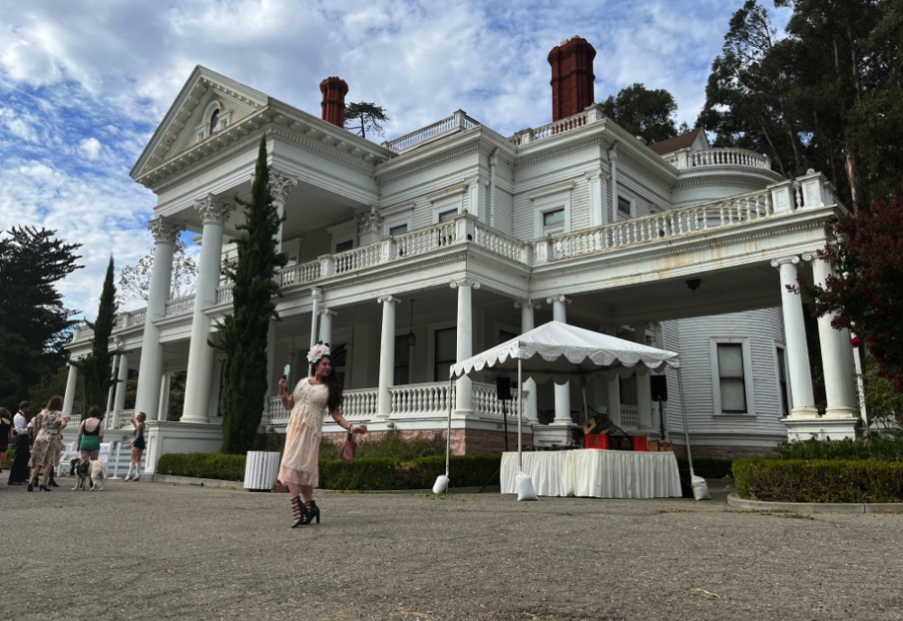 the author of the story poses in front of the mansion