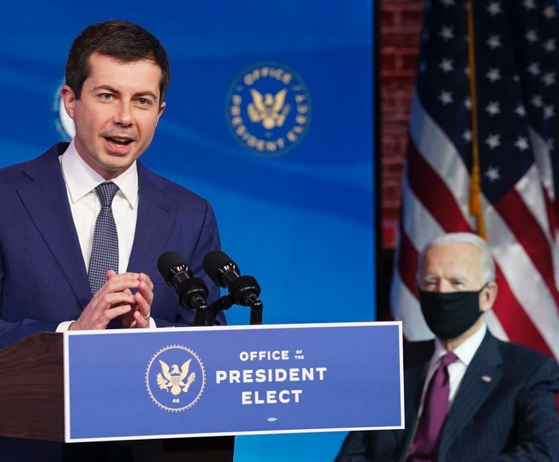 Pete Buttigieg, an option for VP, stands at a podium in front of a blue screen