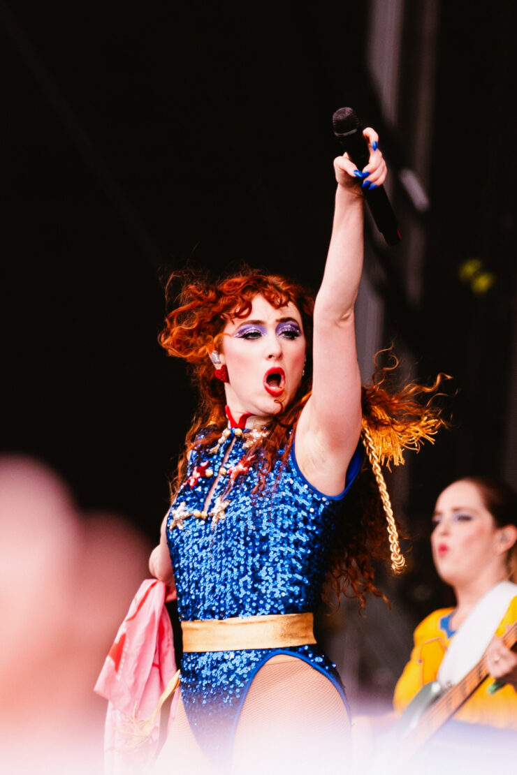 Chappell Roan jumps into the air with a raised fist