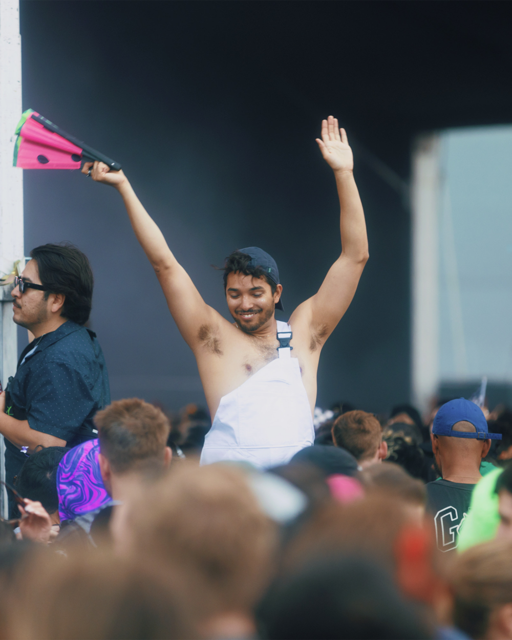 A queer man in the audience waves his fan in the air