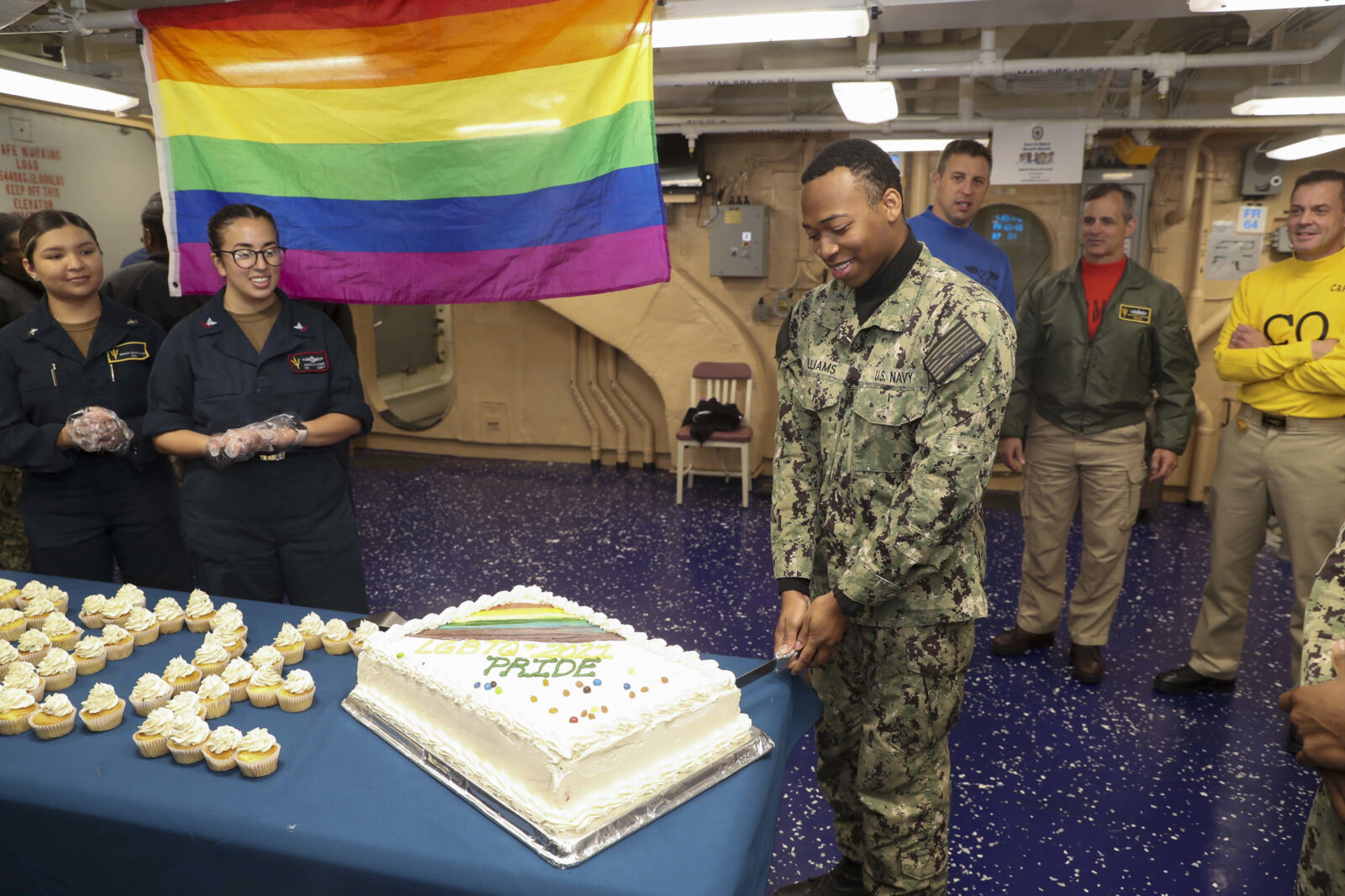 A celebration on an army base including a gay flag and a pride cake