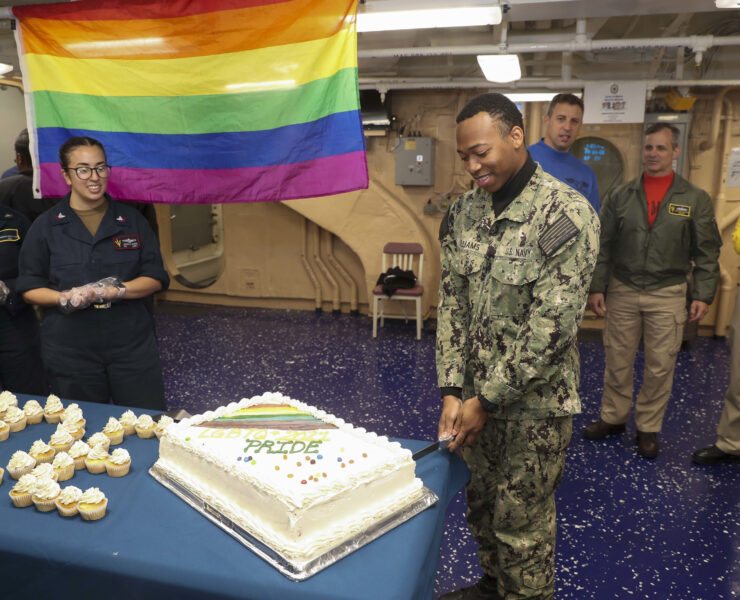 A celebration on an army base including a gay flag and a pride cake