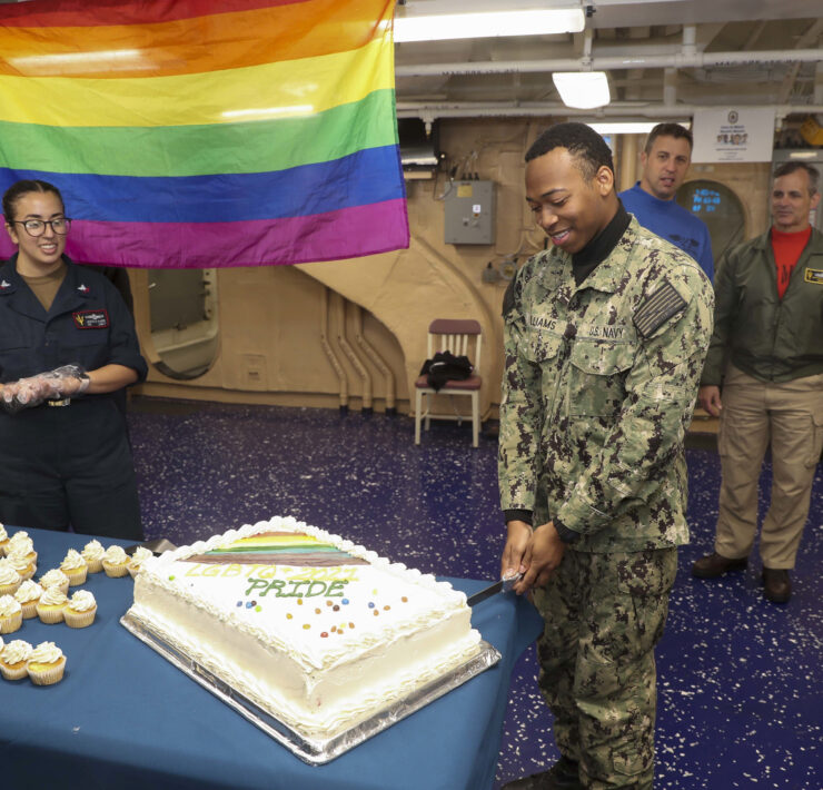 A celebration on an army base including a gay flag and a pride cake