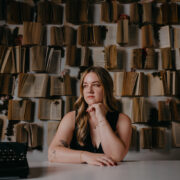 Author portrait of woman in front of book wall.