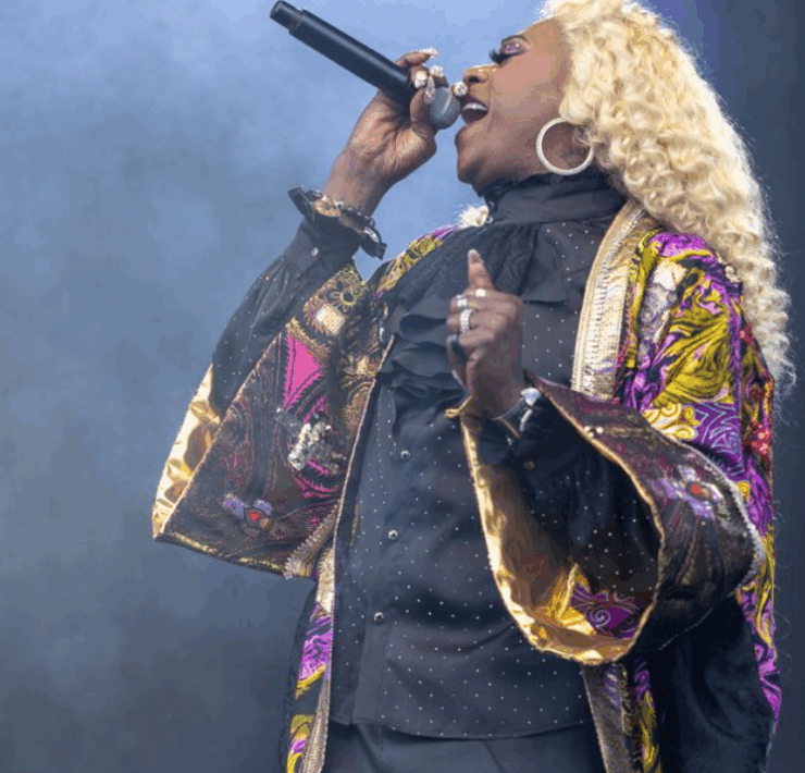 profile shot of big freedia singing with fog/smoke behind her