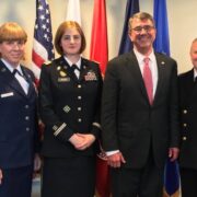 a group of trans military activists standing in front of court flags