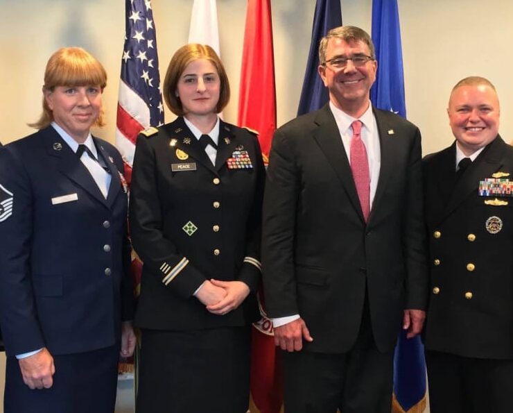 a group of trans military activists standing in front of court flags